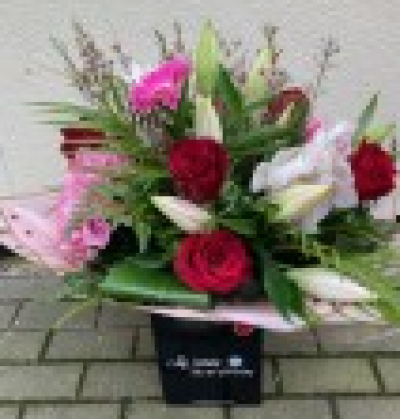 True Love. - Opulent red roses , mixed with a selection of orchids, lily's and hydrangeas, This design will also have a selection of seasonal flowers to enhance the design