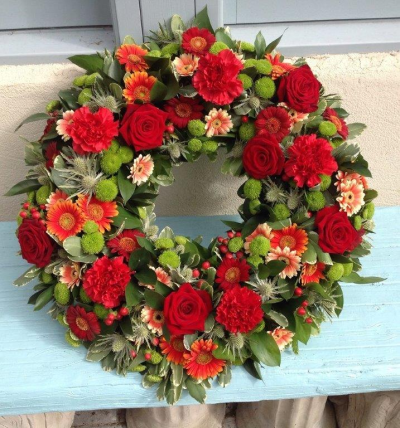 The Red One. - Textured all red wreath using red roses, carnations and gerberas, with complimenting filler flowers and foliage.