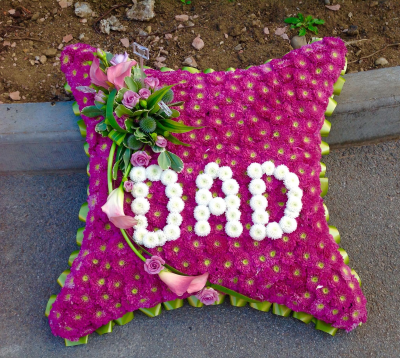Massed Cushion - Flowers massed onto the frame with the word Dad in flowers .